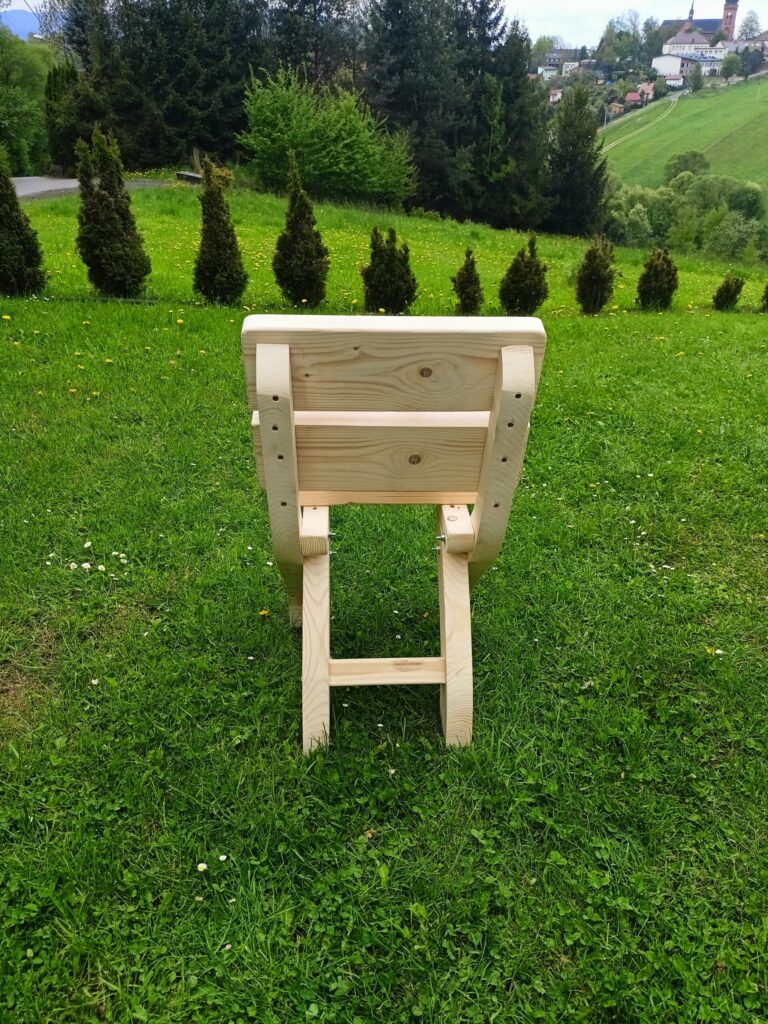 a wooden chair in a grassy field