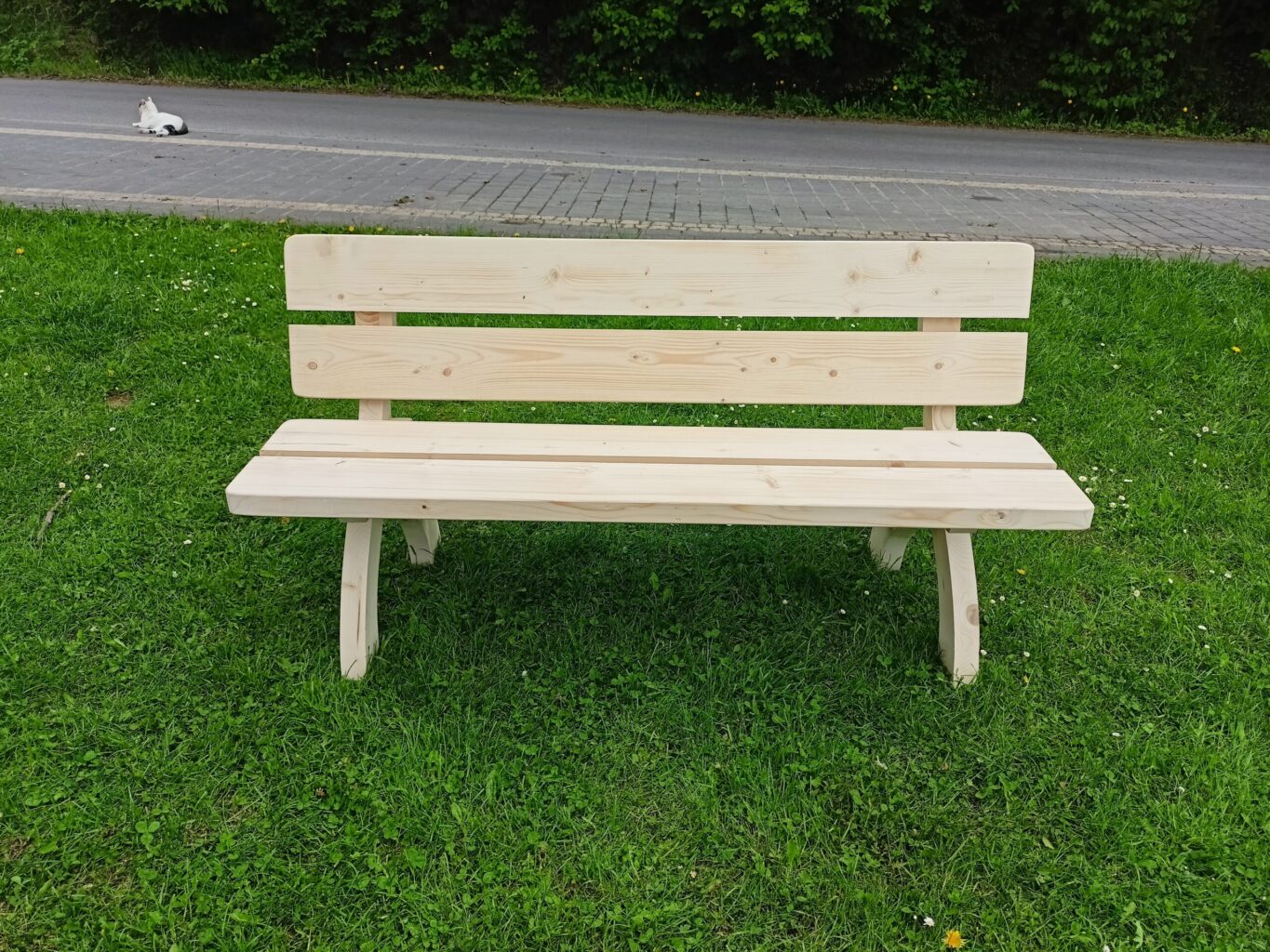 a wooden bench in a grassy area