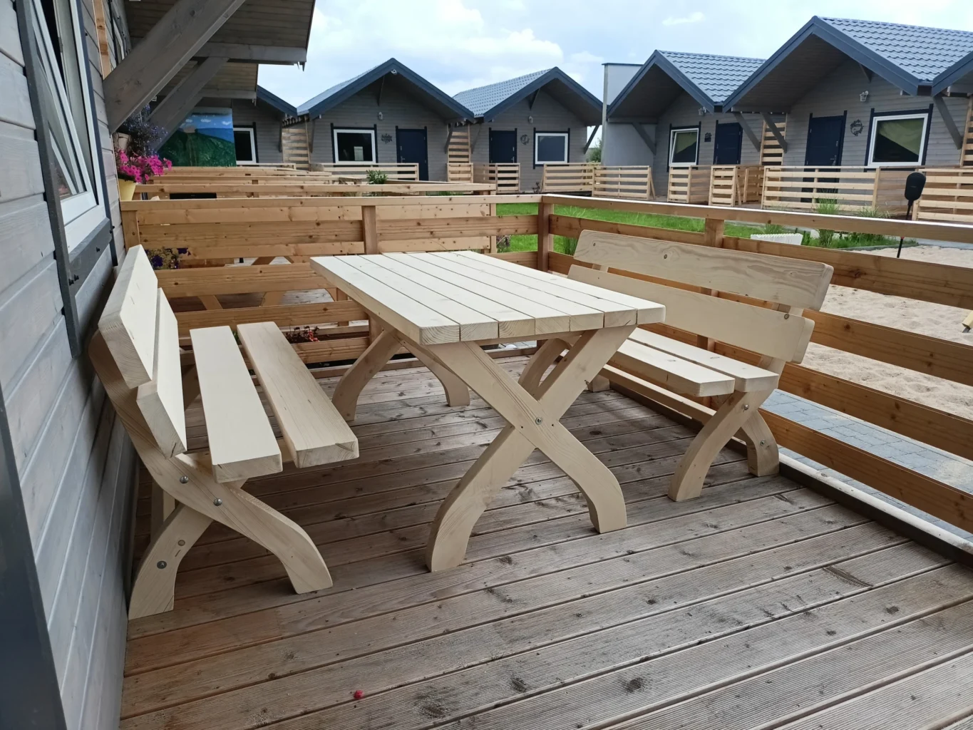 a wooden table and benches on a deck